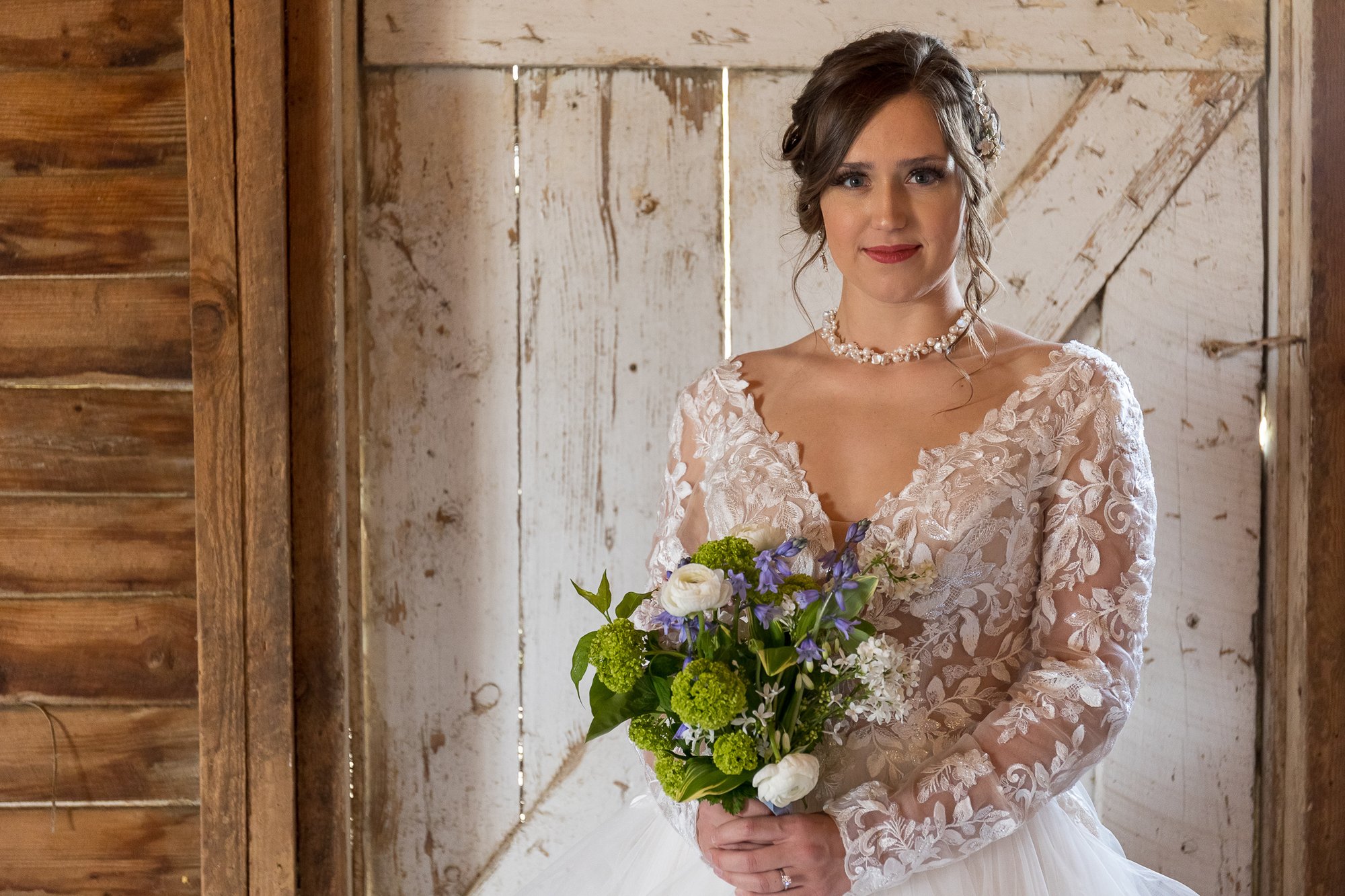 bride in a formal gown in a rustic barn