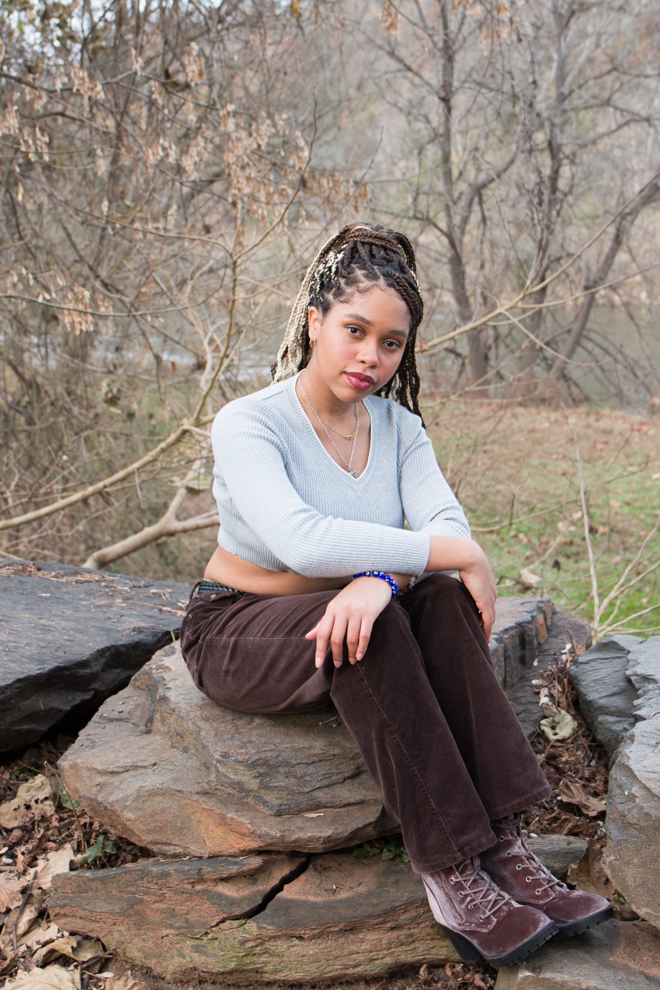 casual outdoor senior on a rock by a river