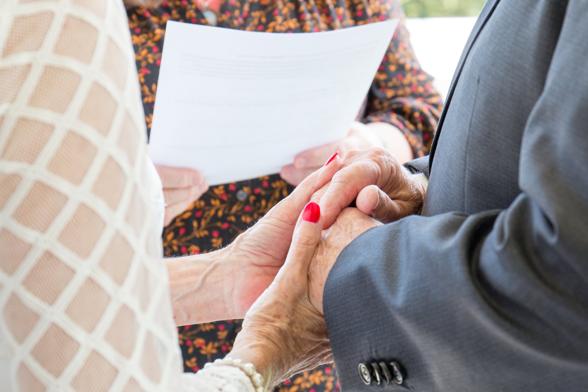 older couple holding hands during ceremony