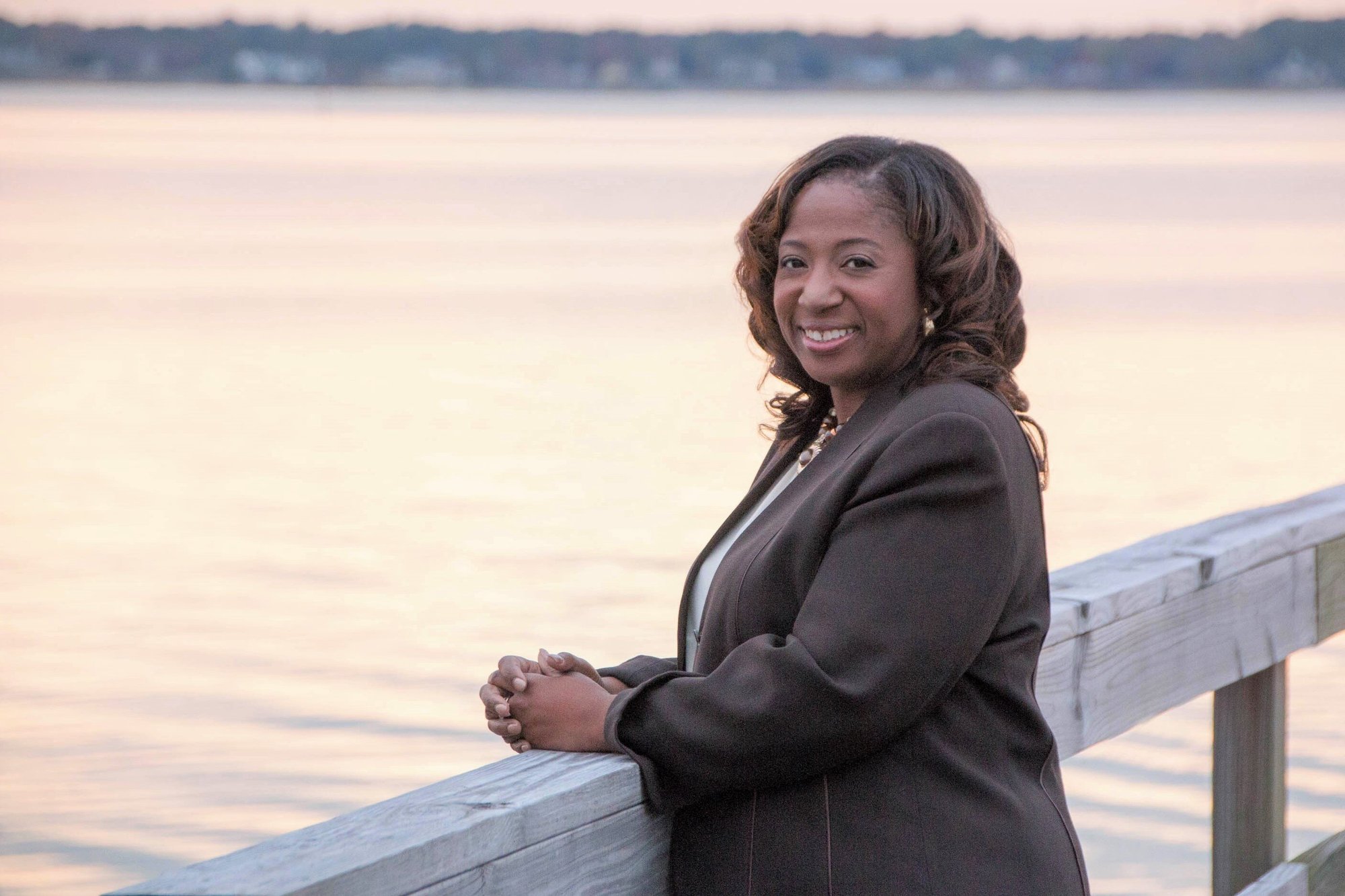 business owner headshot outdoors by water at sunset