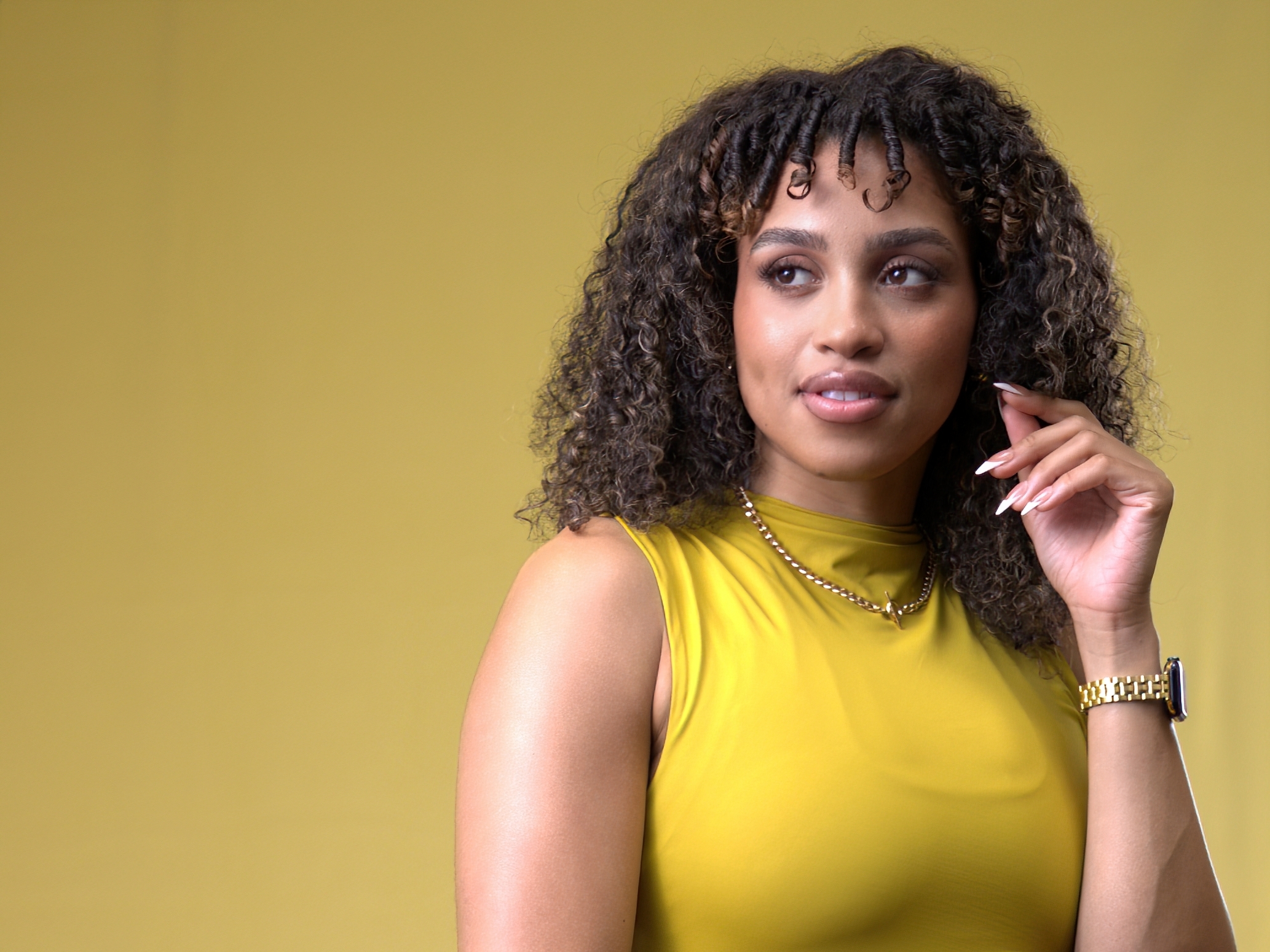 branding lifestyle headshot of a black woman wearing gold on a gold backdrop